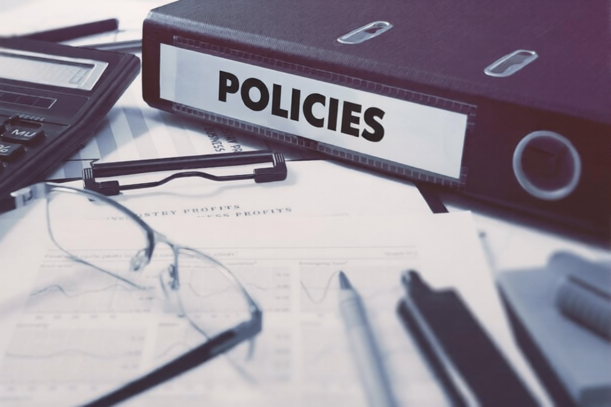 Compliance policy and code of conduct documents on a table